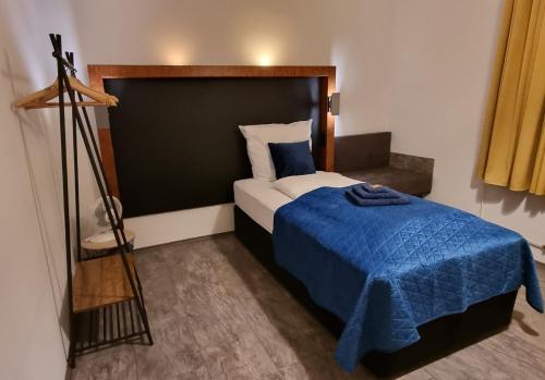 a bedroom with a bed with a blue blanket at Fine Living - Einzeln oder größere Gruppen- 5 Zimmer je mit eigenem Bad - Küche - Aufenthaltsraum - bis 8 Personen in Meine