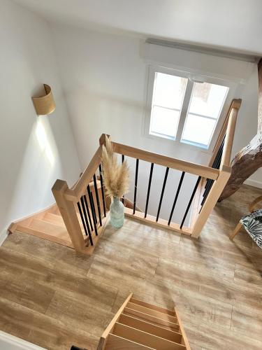 a room with a wooden staircase with a vase on the floor at Le Ptit Gite de Chablis - Maison avec Cour en Centre-Ville in Chablis