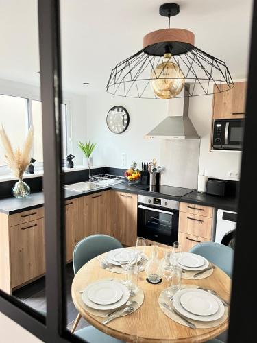 a kitchen with a wooden table and blue chairs at Le Ptit Gite de Chablis - Maison avec Cour en Centre-Ville in Chablis