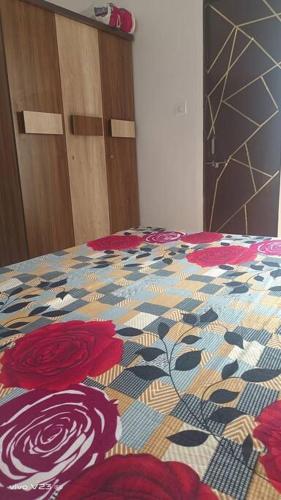 Una cama con un edredón de flores. en Arhan's Villa, en Ahmedabad