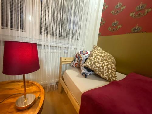 a bedroom with a bed and a table with a lamp at Sweet apartment in Bratislava