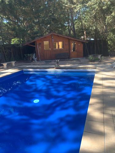 uma piscina em frente a um chalé de madeira em Villa Lujosa con piscina privada 9x5 em Valladolid