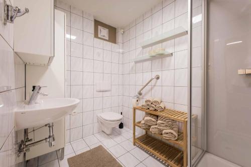 a white bathroom with a sink and a toilet at Apartment Stern in Mieders in Mieders