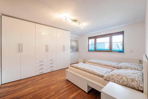 a white bedroom with two beds and a window at Apartment Stern in Mieders in Mieders