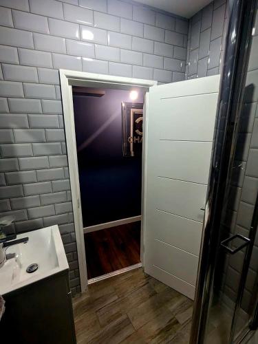 a bathroom with a shower and a sink and a door at Bright & Modern Apartment in Hackney Wick E3 in London