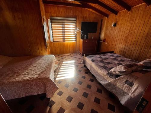 - une chambre avec 2 lits et une télévision dans l'établissement RanchoJC Tranquilidad Naturaleza, à Colbún