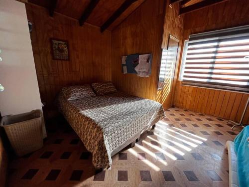 - une chambre avec un lit dans une pièce dotée d'une fenêtre dans l'établissement RanchoJC Tranquilidad Naturaleza, à Colbún