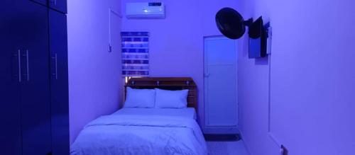 a bedroom with a bed in a purple room at Oseiwe Condo in Lagos