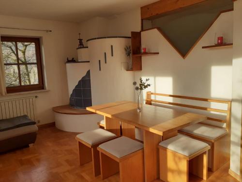 - une cuisine avec une table en bois et quelques tabourets dans l'établissement Zirbentraum, à Lana
