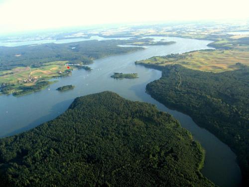 an aerial view of a river with islands and forests at Dom z pięknymi widokami na jezioro ryńskie ilasy. in Rybical