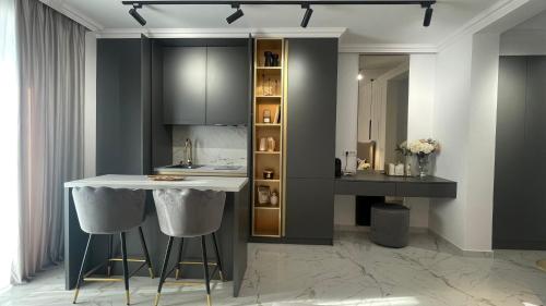 uma cozinha com um lavatório e um balcão com bancos em Vanilla Studio em Timisoara