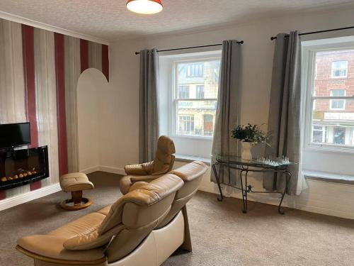 a living room with a couch and chairs and a television at The Flat in central Kirkby Stephen in Kirkby Stephen
