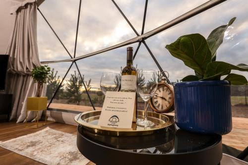 a table with wine glasses and a clock at Glamping Idyllaglamp Loft in Dzbądzek