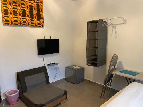 a room with a bed and a tv and a table at Belvoir Apart-Hotel & Residence in Freetown