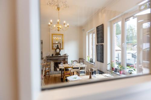 a dining room with a table and a chandelier at Li Ter Hôtel in Marche-en-Famenne