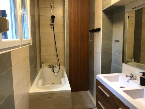 a bathroom with a sink and a bath tub at Maison proche du centre ville - Mitoyenne in Saint Die