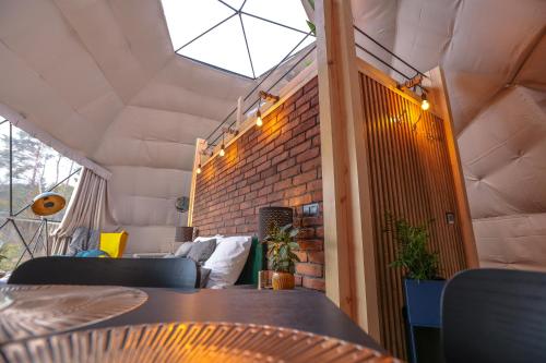 a room with a table and a brick wall at Glamping Idyllaglamp Loft in Dzbądzek