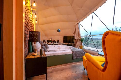 a bedroom with a bed in a room with a window at Glamping Idyllaglamp Loft in Dzbądzek