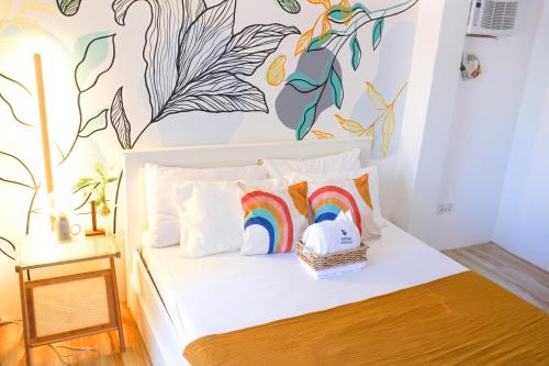 a bedroom with a bed with a rainbow on the wall at Urban Oasis Resort, Tarlac in Tarlac