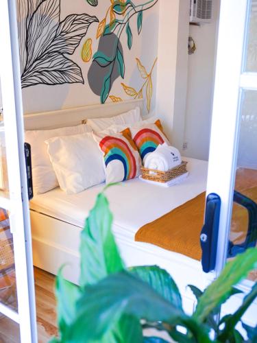 a bedroom with a bed with a rainbow pillow at Urban Oasis Resort, Tarlac in Tarlac