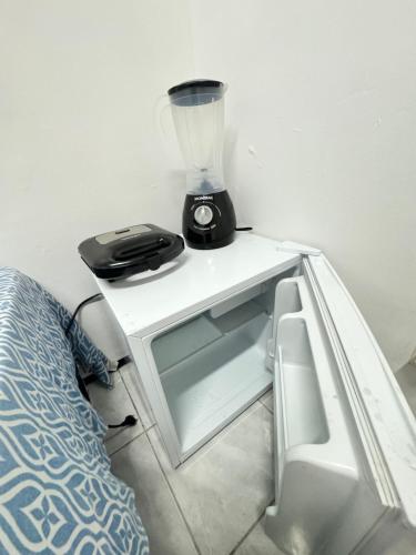 a blender sitting on a table next to a bed at Mini Ap no derby com Garagem in Sobral