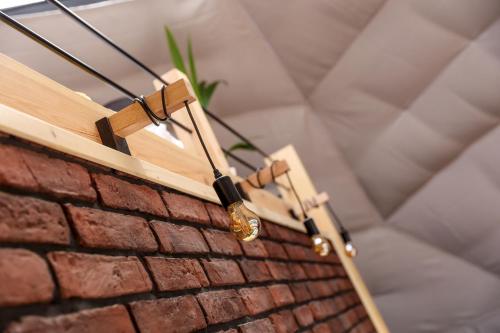 a chandelier hanging from a brick wall at Glamping Idyllaglamp Loft in Dzbądzek