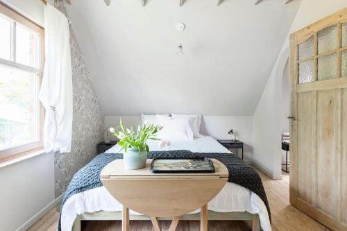 a small bedroom with a bed with a wooden table at Gastenverblijf in Belle epoque woning in Bruges
