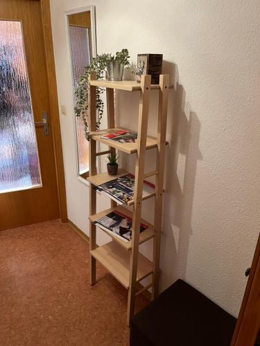 a wooden book shelf in a room with magazines at Ferienwohnung im Herzen Tribergs in Triberg