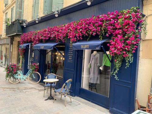 a blue store with flowers on the front of it at Gîte Mas des ricochets in Aigremont