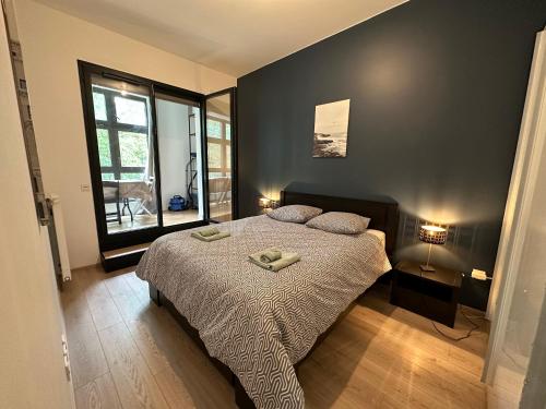 - une chambre avec un lit et une grande fenêtre dans l'établissement appartement au calme avec vue sur parc, proche de Paris, à Stains