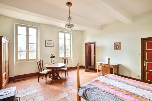 - une chambre avec un lit, une table et des chaises dans l'établissement La Colonie St Joseph - Gîtes pour 6 de charme, à Labastide-Savès