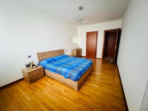 een slaapkamer met een bed en een houten vloer bij Veronica Apartament in Dosson