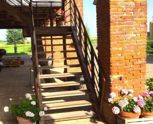una escalera de madera junto a una pared de ladrillo con flores en Rustic Parma Retreat en Montechiarugolo