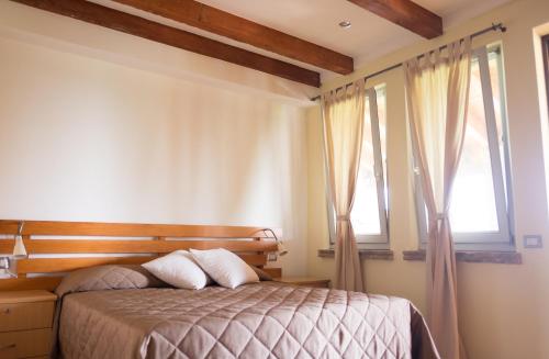 1 dormitorio con 1 cama y 2 ventanas en Rustic Parma Retreat en Montechiarugolo