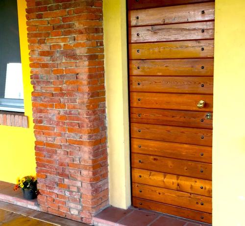 una puerta de madera en un lateral de una pared de ladrillo en Rustic Parma Retreat, en Montechiarugolo