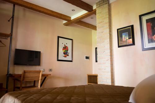 1 dormitorio con 1 cama y TV de pantalla plana en Rustic Parma Retreat en Montechiarugolo