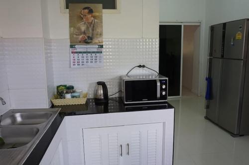 a kitchen with a sink and a microwave on a counter at The Living - Holiday Home Phayao in Phayao