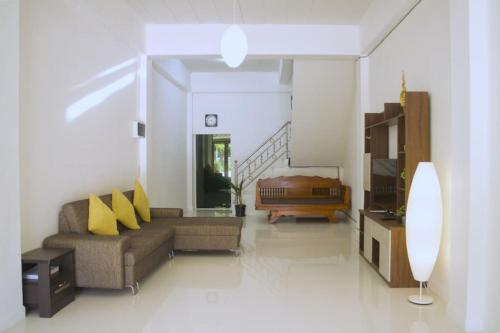 a living room with a couch and a bed at The Living - Holiday Home Phayao in Phayao