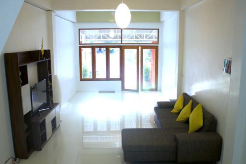 a living room with a couch and a television at The Living - Holiday Home Phayao in Phayao