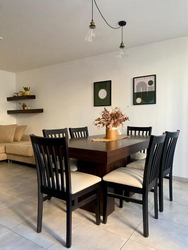 a dining room with a table and chairs and a couch at Departamento amoblado in Villa María