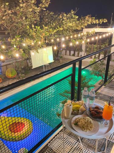 a table with food and drinks next to a pool at Urban Oasis Resort, Tarlac in Tarlac