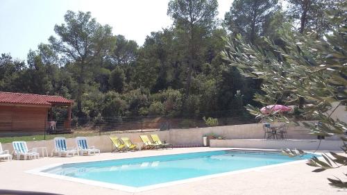 een zwembad met stoelen en een hek bij Gites Les Chrisalies in Pont-Saint-Esprit