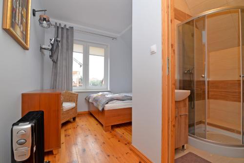a bathroom with a shower and a bed and a sink at Villa Andre in Jarosławiec