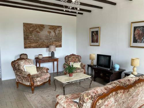 a living room with two couches and a tv at B&B at 3 La Brionniere in Saint-Pierre-du-Chemin