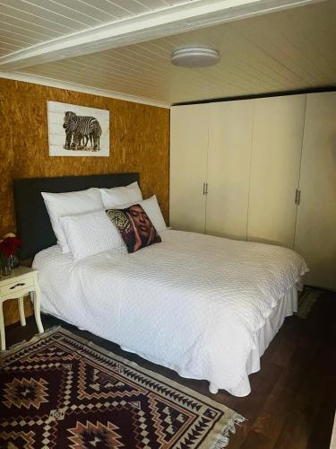 a bedroom with a large white bed and a rug at 43 wood in Cape Town