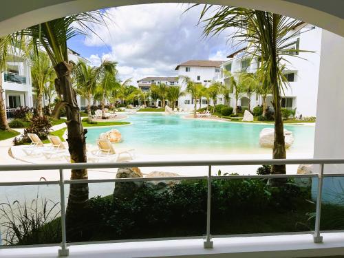 vistas a una piscina con palmeras en Komfortowy Apartament z 4 Basenami i Pięknym Ogrodem, Estrella Dominicus-Bayahibe, en Bayahibe