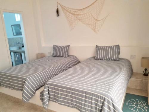 two beds sitting next to each other in a bedroom at Yellow Heron House in Puerto Villamil