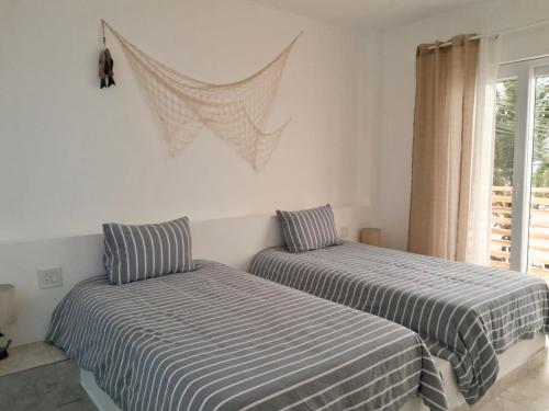 two beds sitting next to each other in a bedroom at Yellow Heron House in Puerto Villamil