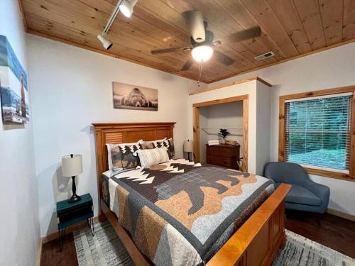 a bedroom with a bed and a chair in it at Nantahala Nook, cabin w/hot tub,game room, & wifi in Bryson City