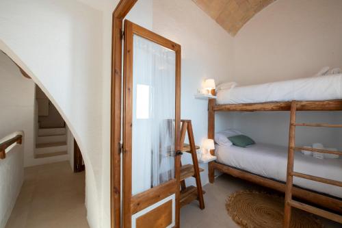 a room with two bunk beds and a staircase at Casa Concha Apartamentos in Calella de Palafrugell